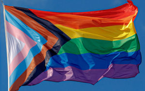 An inclusive pride flag flying in the wind